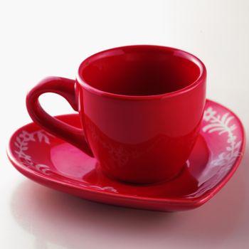 Red cup with heart plate over white background