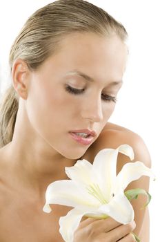 blond and beautiful girl with wet hair looking down a white lily