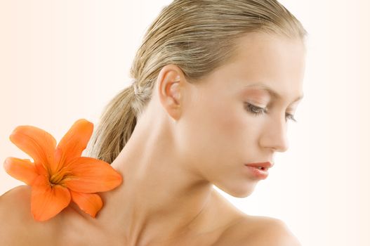 great portrait of a blond girl with an orange flower on her shoulder