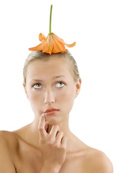 funny portrait of a pretty girl looking thoughtful and using a flower as a hat