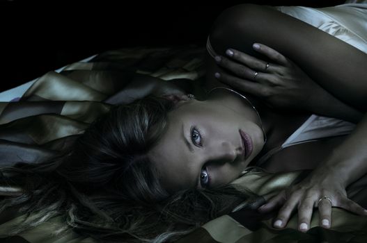 close up of blond woman laying down between the sheet