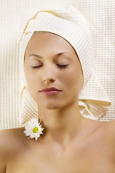 nice portrait of a young woman with bath towel and flowers on neck