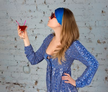 woman with sunglasses drinking a red cocktail