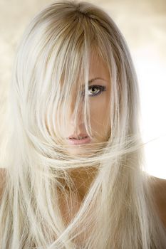 fashion portrait of a cute blond girl with long hair on yellow background