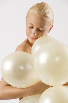 sweet blond girl arming some air ballons with closed eyes in act to sleep