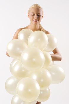 very cute blond woman with some air balloons in front of her body looking down