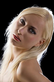 sensual portrait of beautiful blond woman with a fashion make up on black background and back light