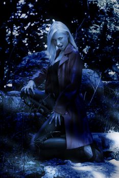 blond sexy woman outside in park looking like a vampire during th night