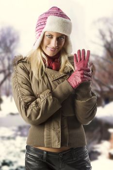 beautiful blond girl wearing a winter breakwind jacket scarf gloves and pink hat