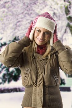 very cute blond girl wearing a winter breakwind jacket scarf gloves and pink hat