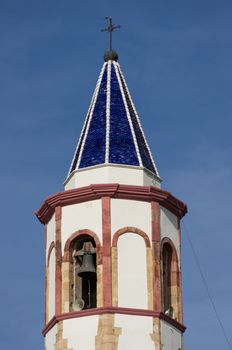 Bell tower with blue tiles of a church Sardinian