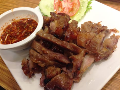 the dish of grilled pork and spicy sauce , thai food