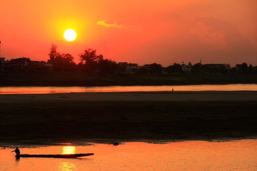 Silhouetted boat on Mekong river at sunset, Vientiane, Laos, Southeast Asia