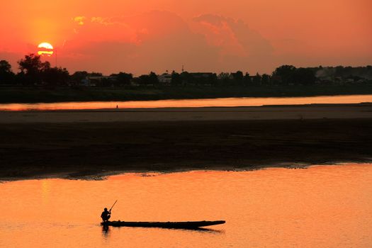 Silhouetted boat on Mekong river at sunset, Vientiane, Laos, Southeast Asia