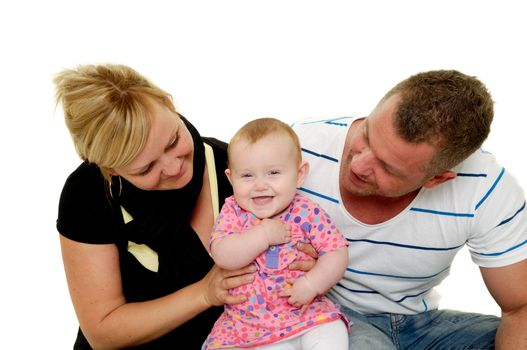 Happy smiling and laughing family. Mother and father are looking at their sweet smiling 4 month old baby.