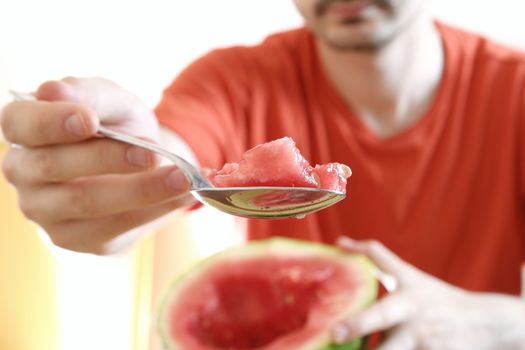 Man eating a slice of watermelon.