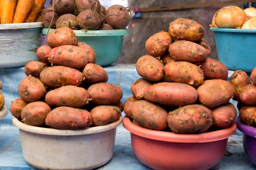 Two pails of potatoes on market counter