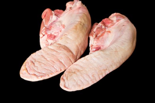 Photo of raw pork tongue on black background