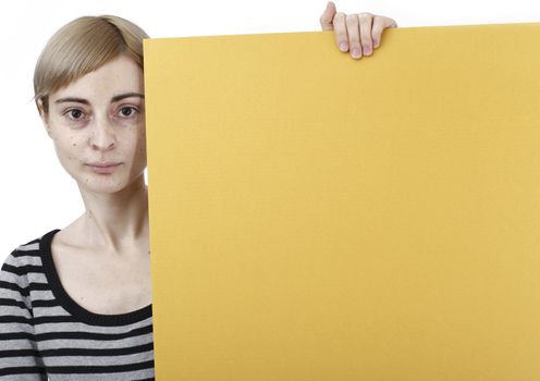 Young blonde woman holding a blank piece of paper.