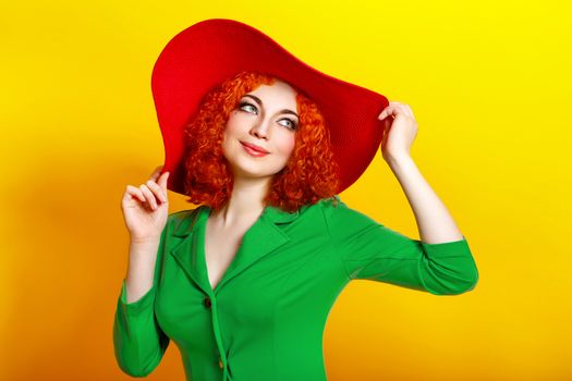 Attractive red-haired girl in red shady hat shot closeup