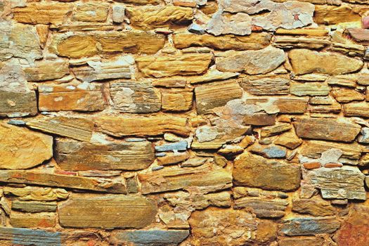 Old stone wall with sandstone rocks ocher color