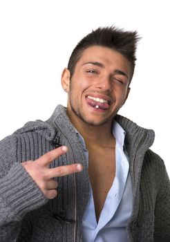 Attractive young man smiling with tongue piercing, doing victory sign with two fingers