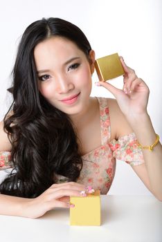 portrait of beautiful smiling healthy asian woman model is holding cosmetic container