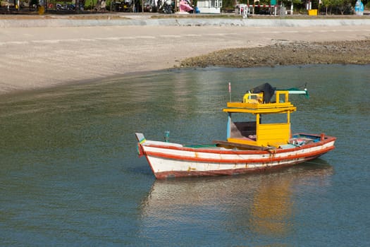 Small fishing boat. Moored in the sea beach is a small fish.