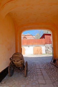 An arch in an old house, a cart with a keg and a ladder, Skansen, Stockholm