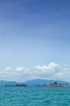 cargo ship Moored near the island behind a mountain.
