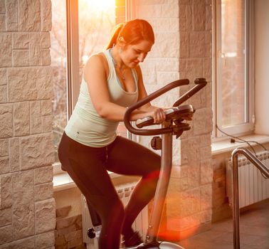 Photo of beautiful woman on exercise bike at gym