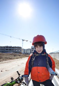 young builder in a red helmet on a background of construction