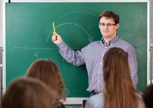 Teacher at university in front of a chalkboard