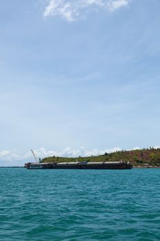 Large cargo ship. Moored at sea. Island near the docks.