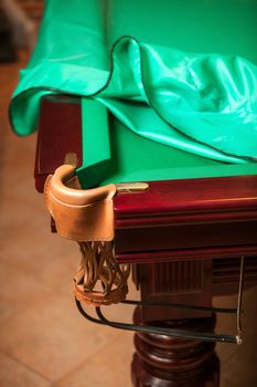 Billiard table under cloth cover with open pocket