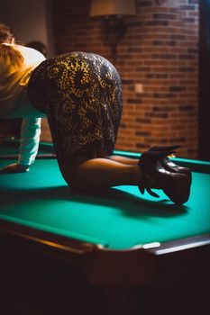 Photo of woman in skirt and stockings kneeling on billiard