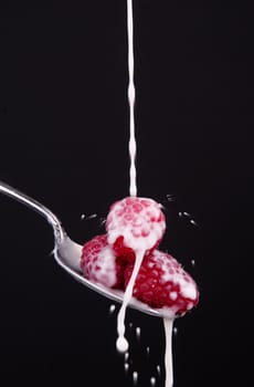A few pieces of fruit in a spoon milk dropping