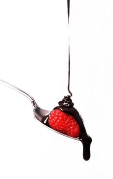 Chocolate sauce hits the berry on a spoon