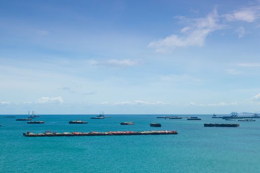 Cargo ships. Moored offshore. In the daytime sky with little clouds.