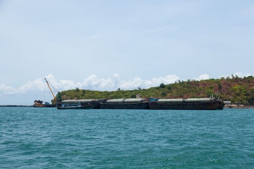Large cargo ship. Moored at sea. Island near the docks.