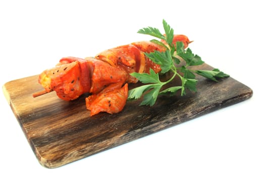 raw, marinated skewered meat in front of white background