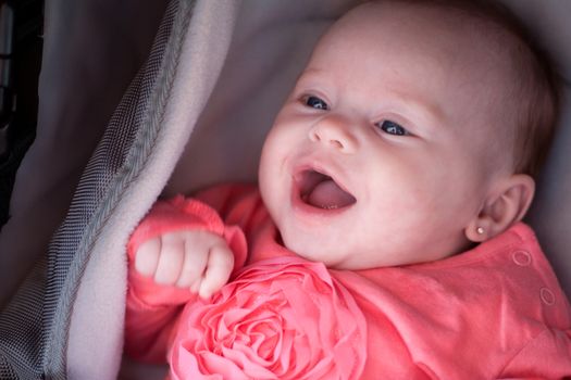 Happy baby is smiling in her pram
