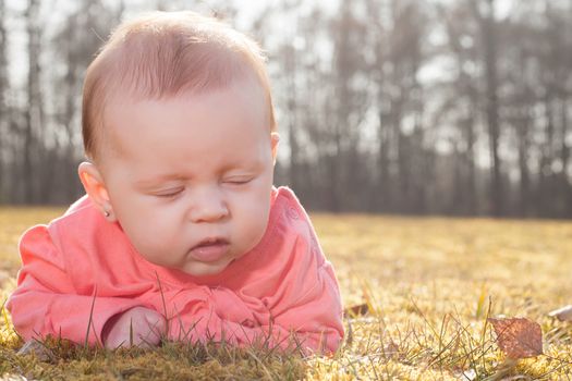 Little baby on the grass in the sun