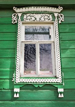 Window with white trim on the green wall rustic house