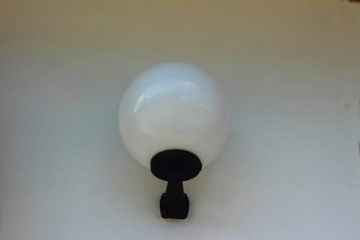 A street lamp in the ceiling of a round white light on the wall