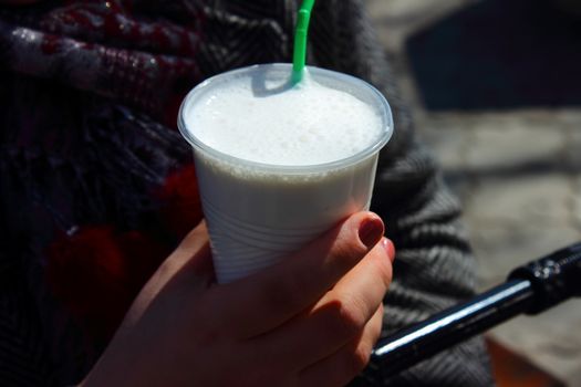 Glass of milkshake in a female hand