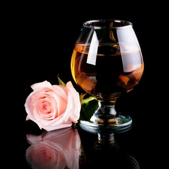 Glass and rose. Alcohol and flower. Glass with drink and a pink rose.