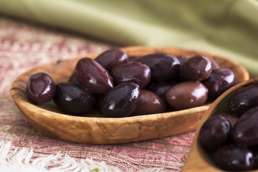 Kalamata olives in a small wooden bowl