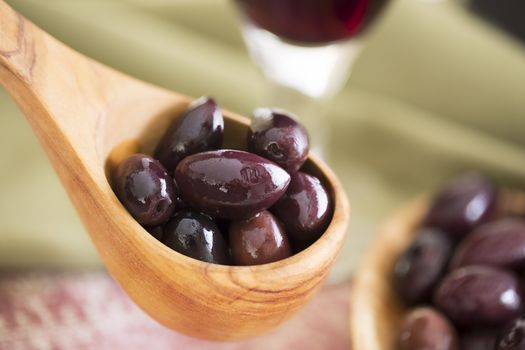 Wooden scoop of kalamata olives.