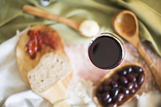 Red wine in glass from directly above with tapas out of focus on table.